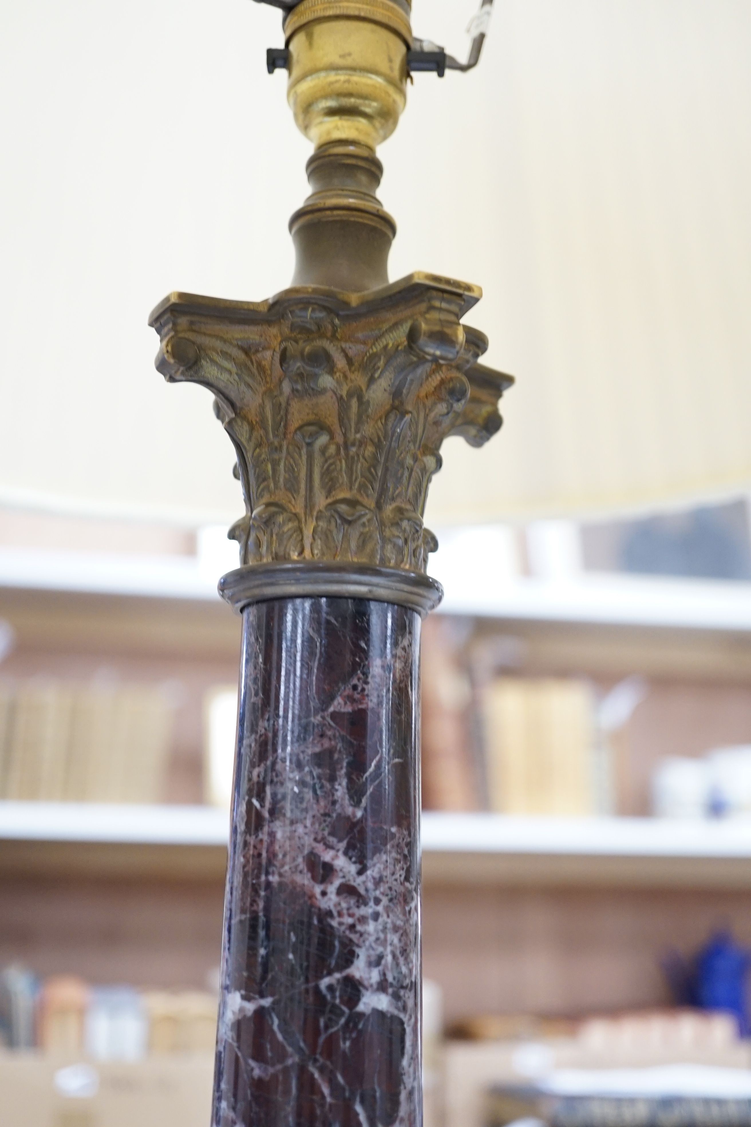 A brass and variegated marble Corinthian column lamp base, 47cms high, not including light fitting.